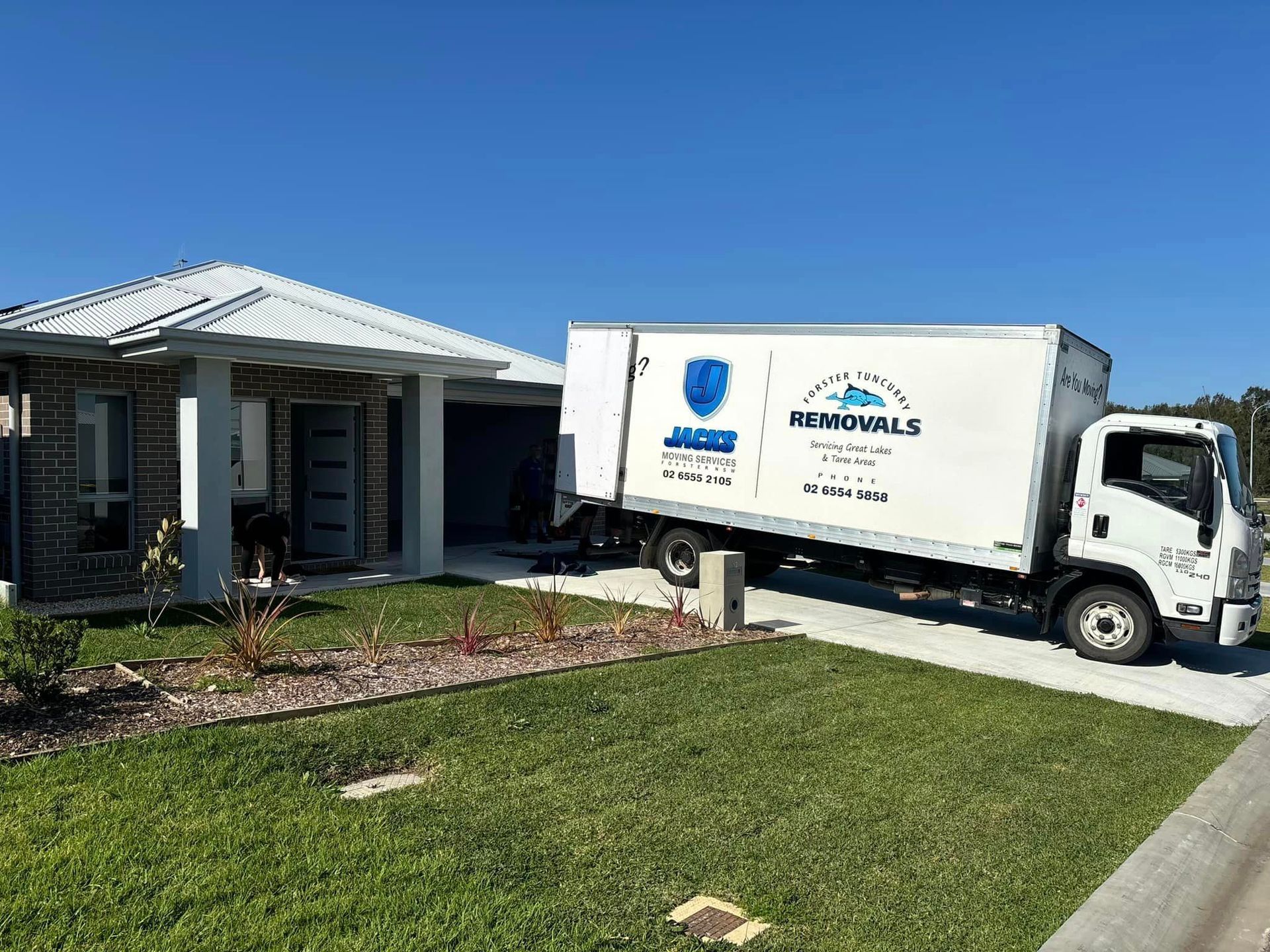 Moving Truck Parked in Front of a Suburban House — Forster Tuncurry Removals & Storage in Forster, NSW