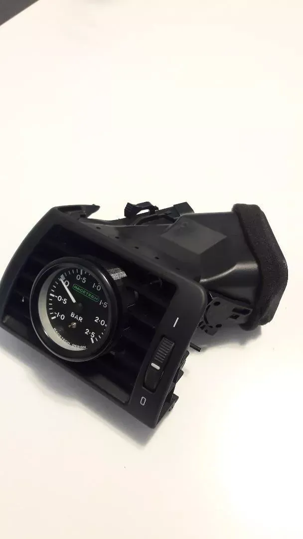Black car air vent with gauge.
