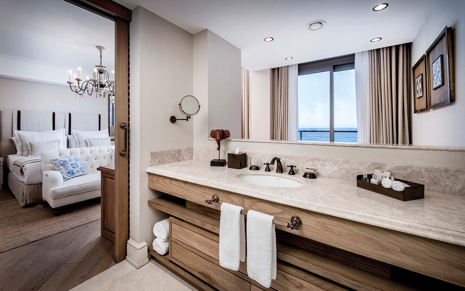 A bathroom in a hotel room with a sink and a mirror.