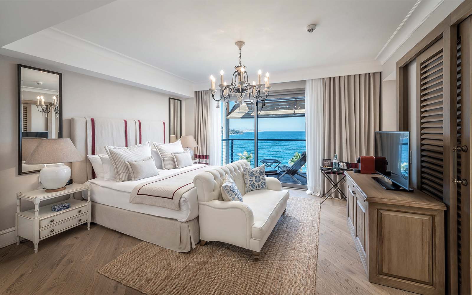 A hotel room with a large bed , couch , and television.