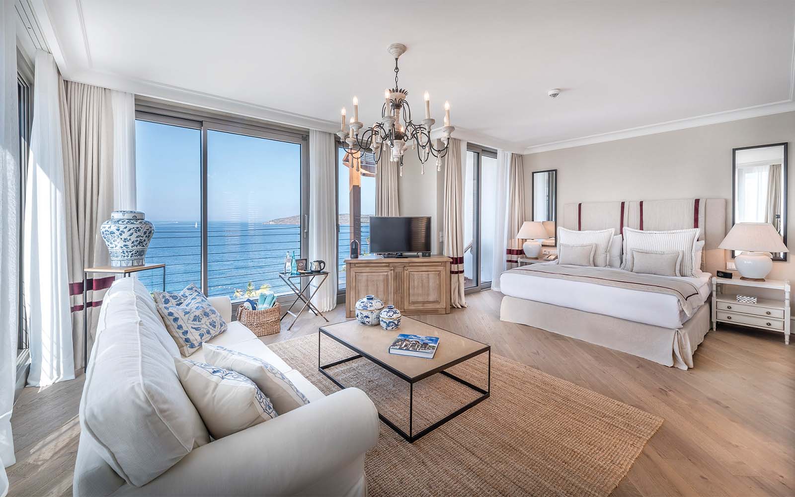 A living room with a bed , couch , coffee table and television.
