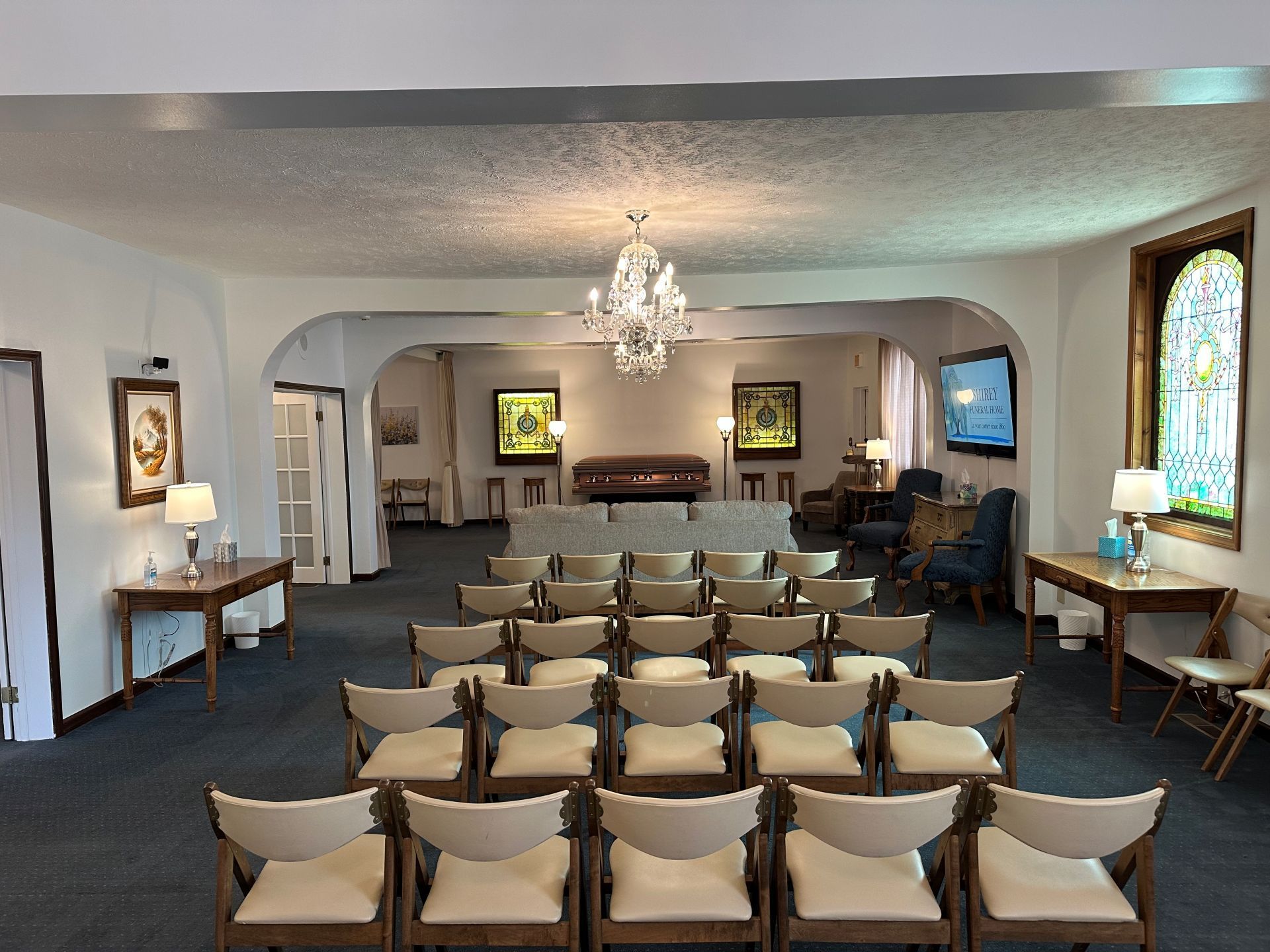 A large room with rows of chairs and a chandelier.