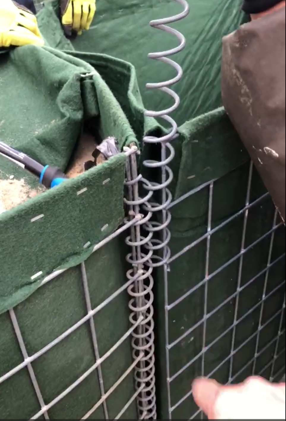 Connecting hesco bastion without joining pins by screwing a coil to a coil