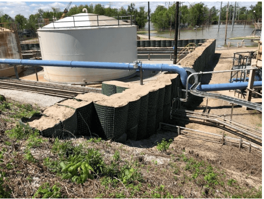 This shows the HESCO flood barrier protecting oil and gas facilities. It shows an 8' tall stacked configuration that ties into an existing levee. You will also see the buttress cell that were included to reinforce the floodwall at the levee tie-in
