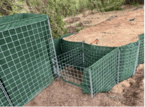 Modified HESCO flood barrier stepping up a levee without disturbing the levee and keeping level. These cells need to be lined completely with fabric and they are ready to fill.