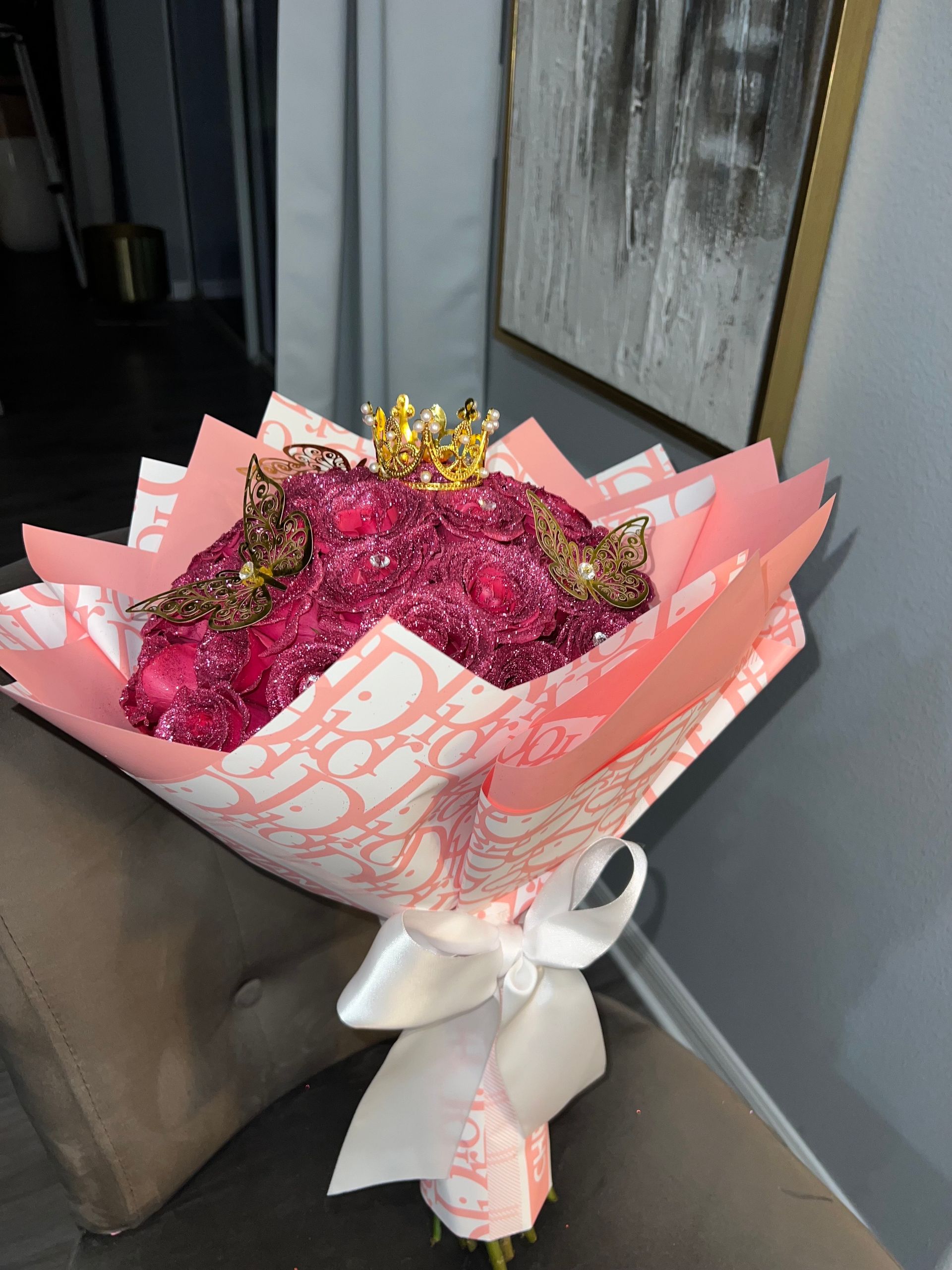 A bouquet of pink flowers wrapped in pink dior paper