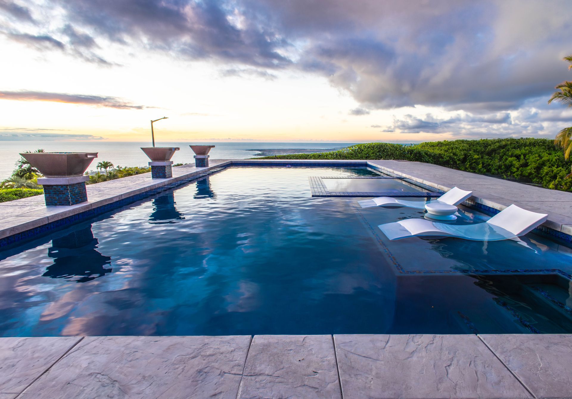 A large swimming pool with a view of the ocean.
