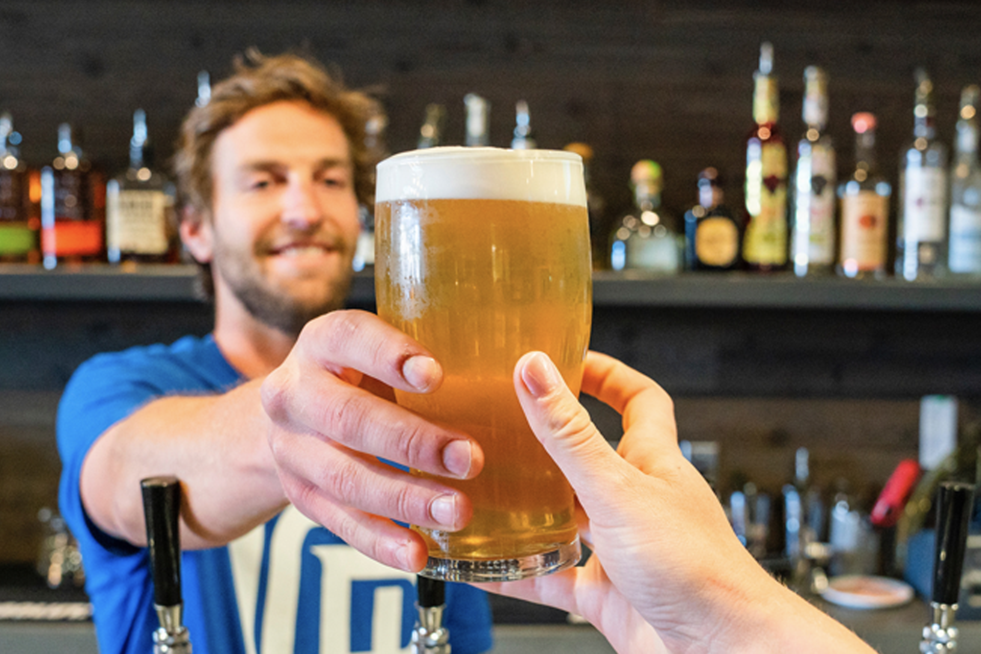 Barman handing over a pint