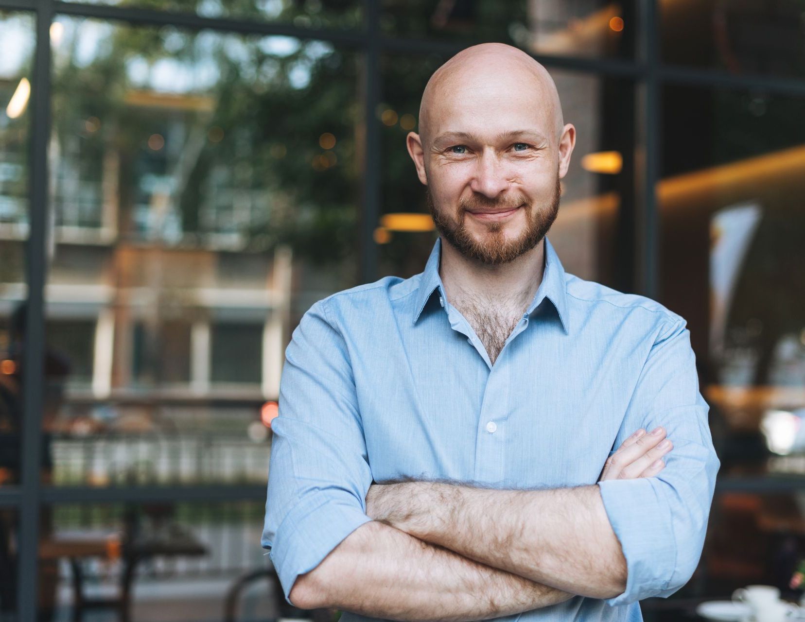 Man smiling standing in front of a bar