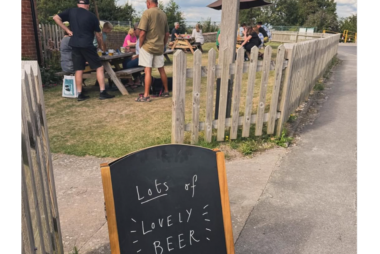 An outdoor pub scene with a chalkboard sign: