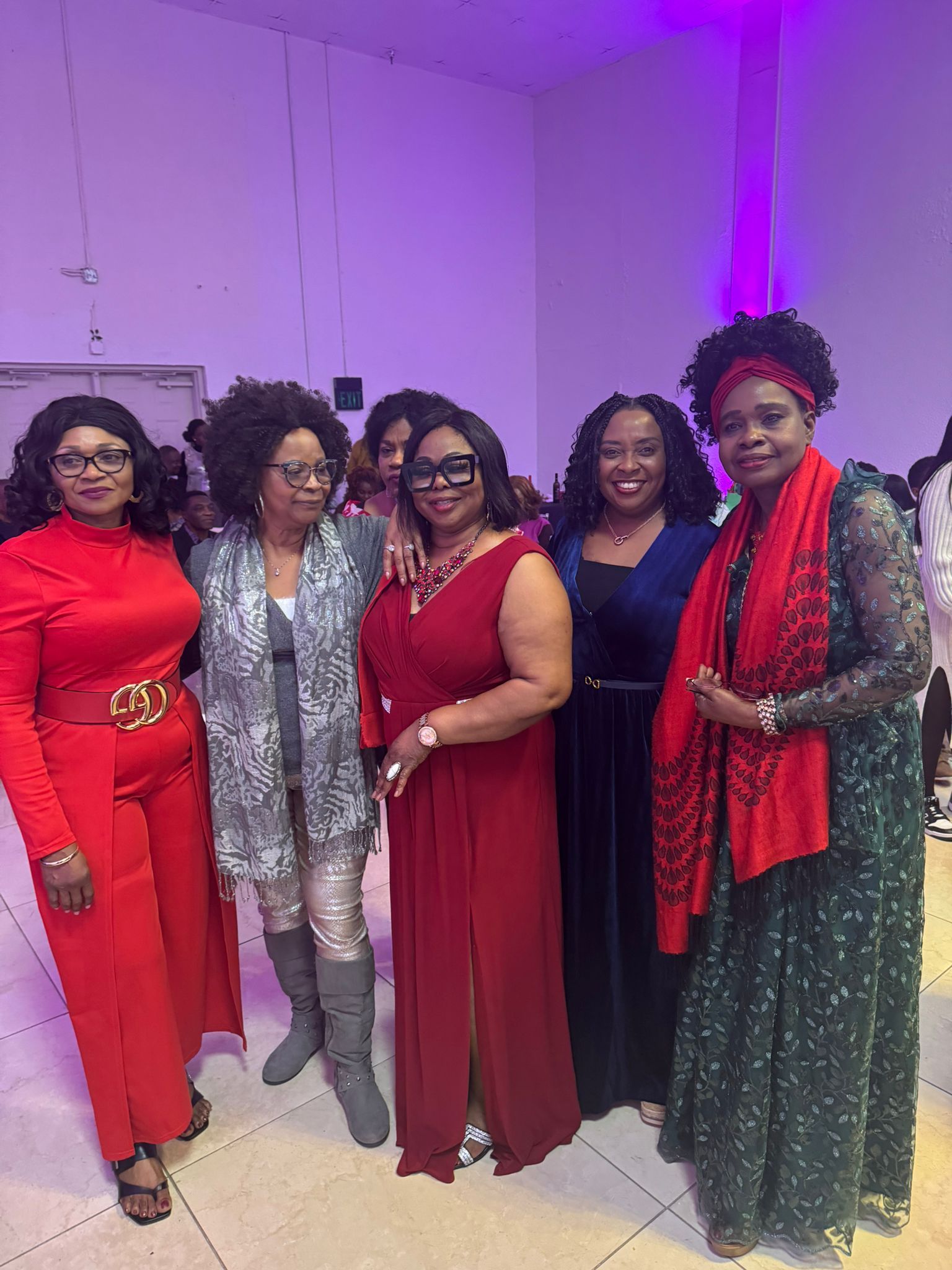 A group of women are posing for a picture together in a room.