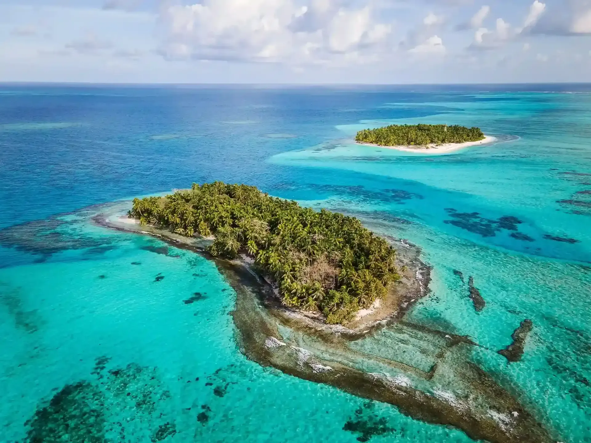 Vista aérea de um ilhote cercado por águas turquesas — um exemplo do encanto natural do Caribe colombiano.