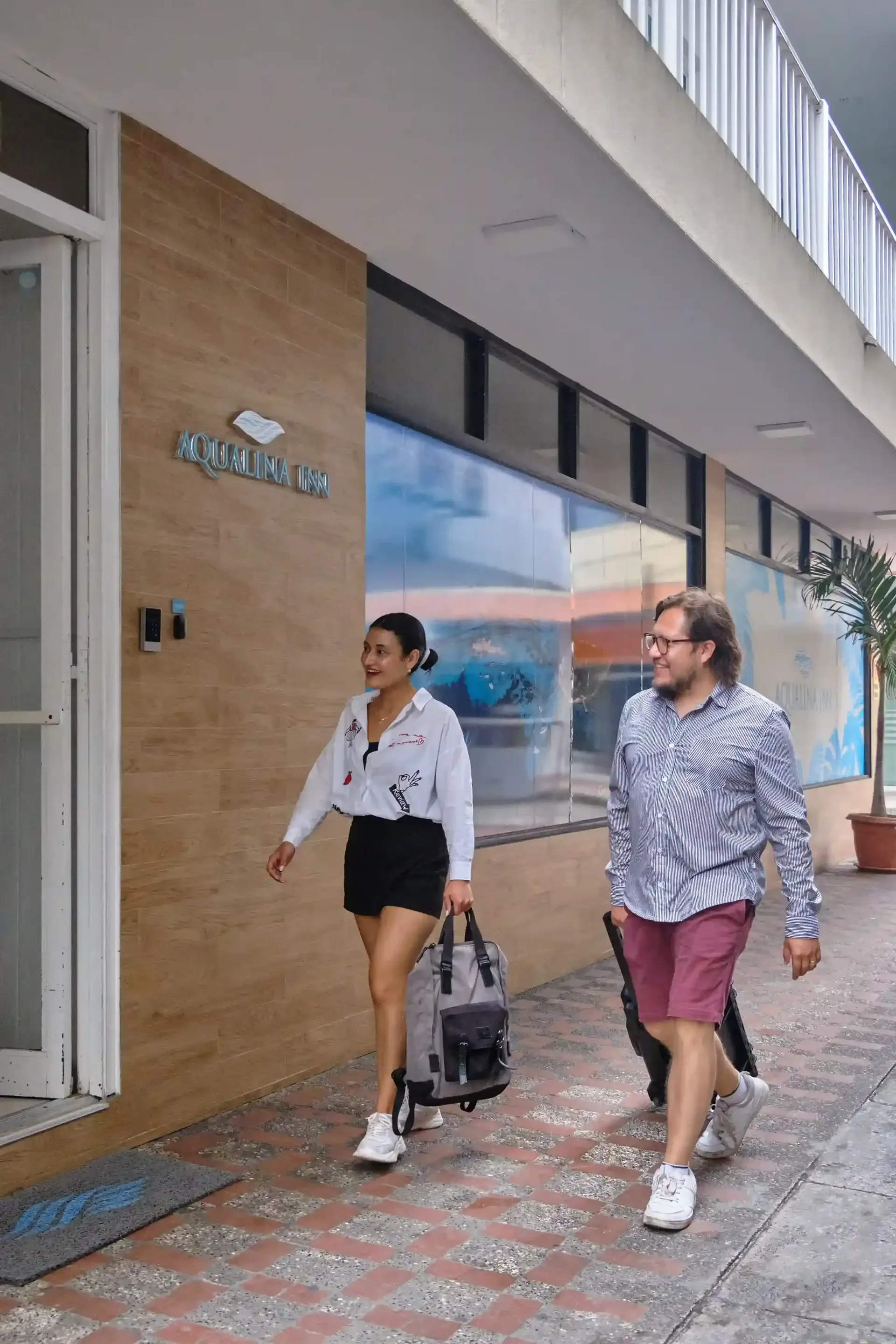 Couple walking with luggage to stay at Aqualina Inn, a hotel in San Andrés