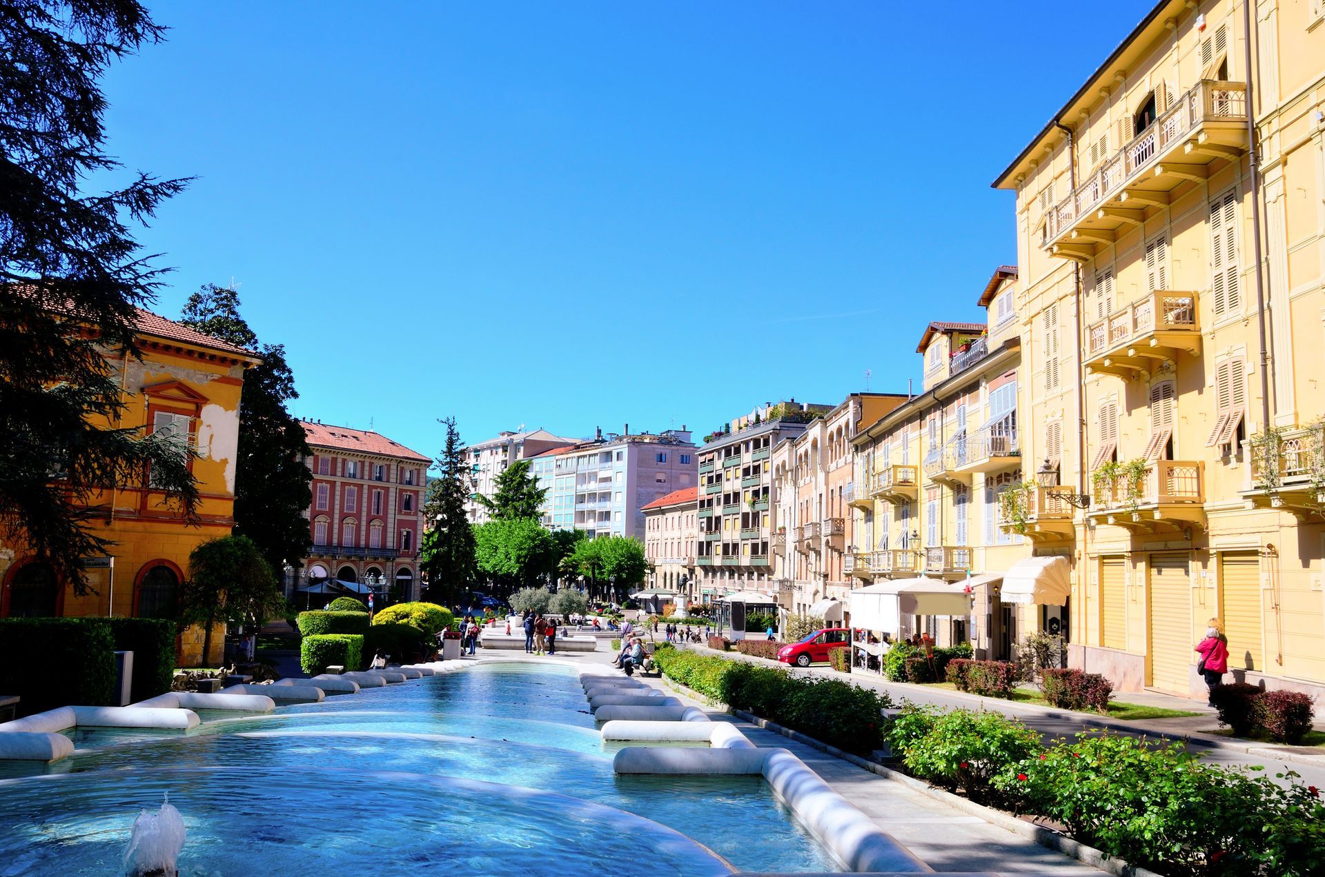 Un canale soleggiato lungo il fiume, fiancheggiato da edifici colorati, sotto un cielo azzurro e limpido.