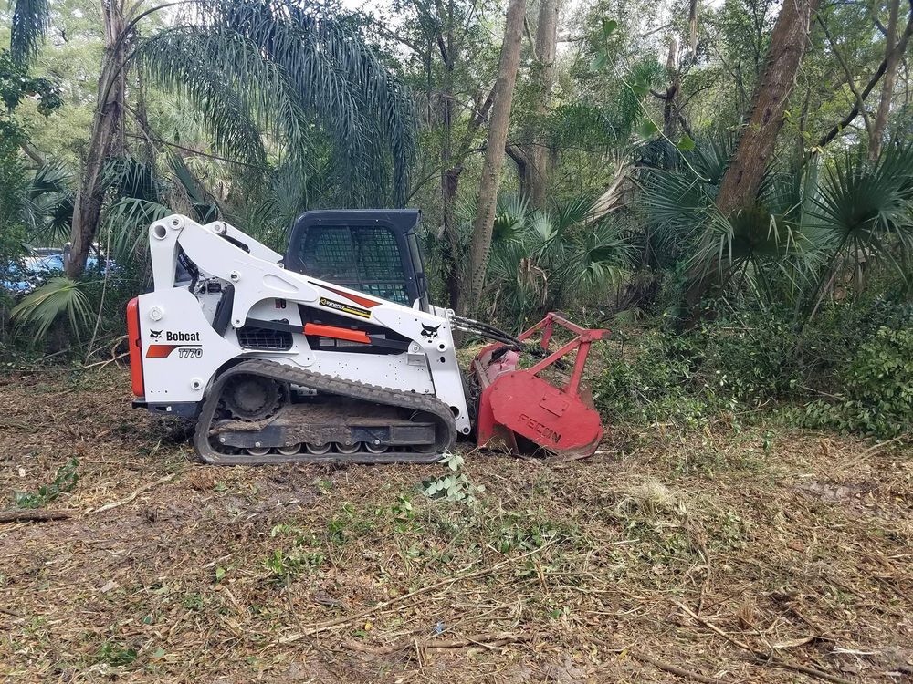 A bulldozer is sitting in the middle of a forest.