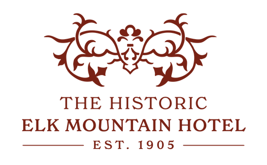 A red oval logo for the historic elk mountain hotel.