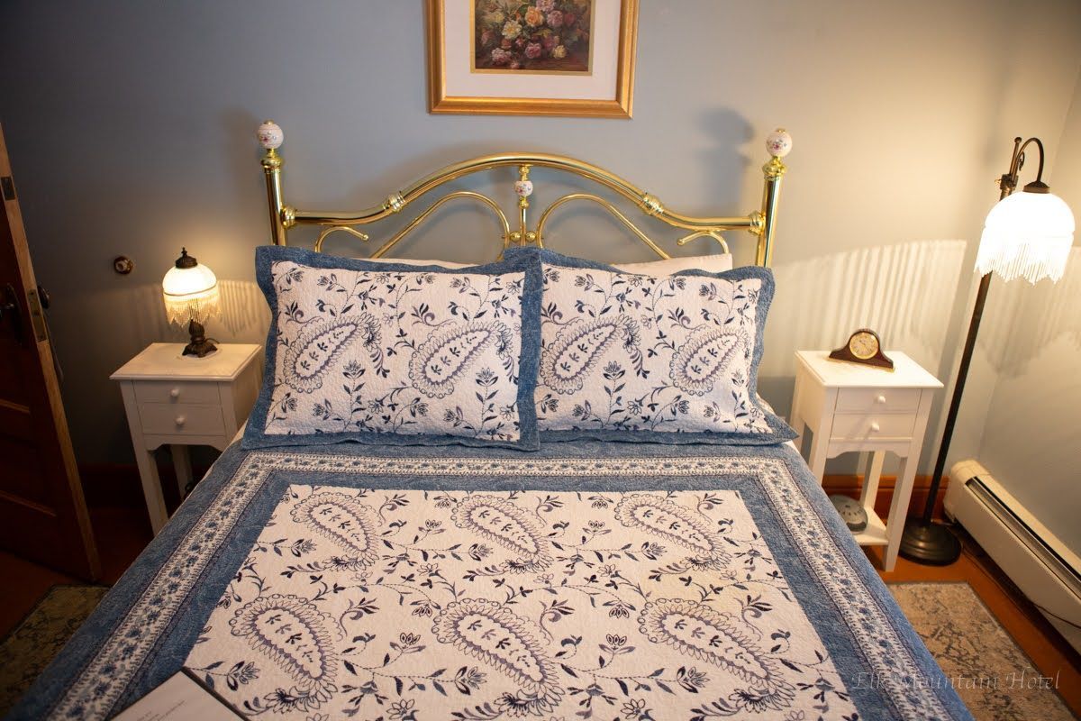 A bedroom with a bed , two nightstands and a lamp