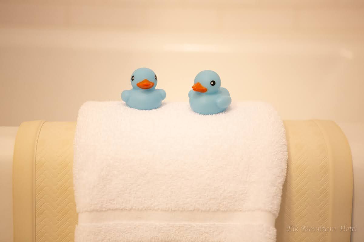 Two blue rubber ducks are sitting on top of a white towel.