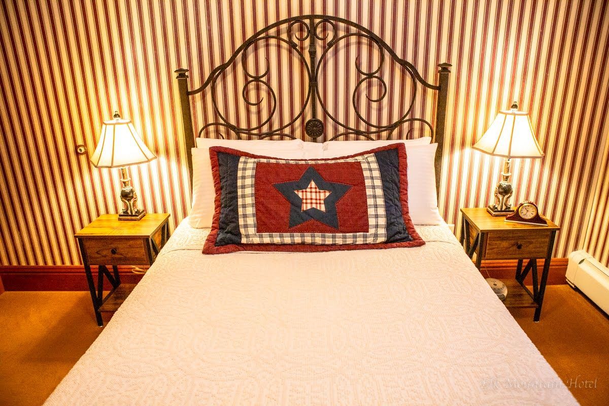 A bed with a red white and blue pillow with a star on it