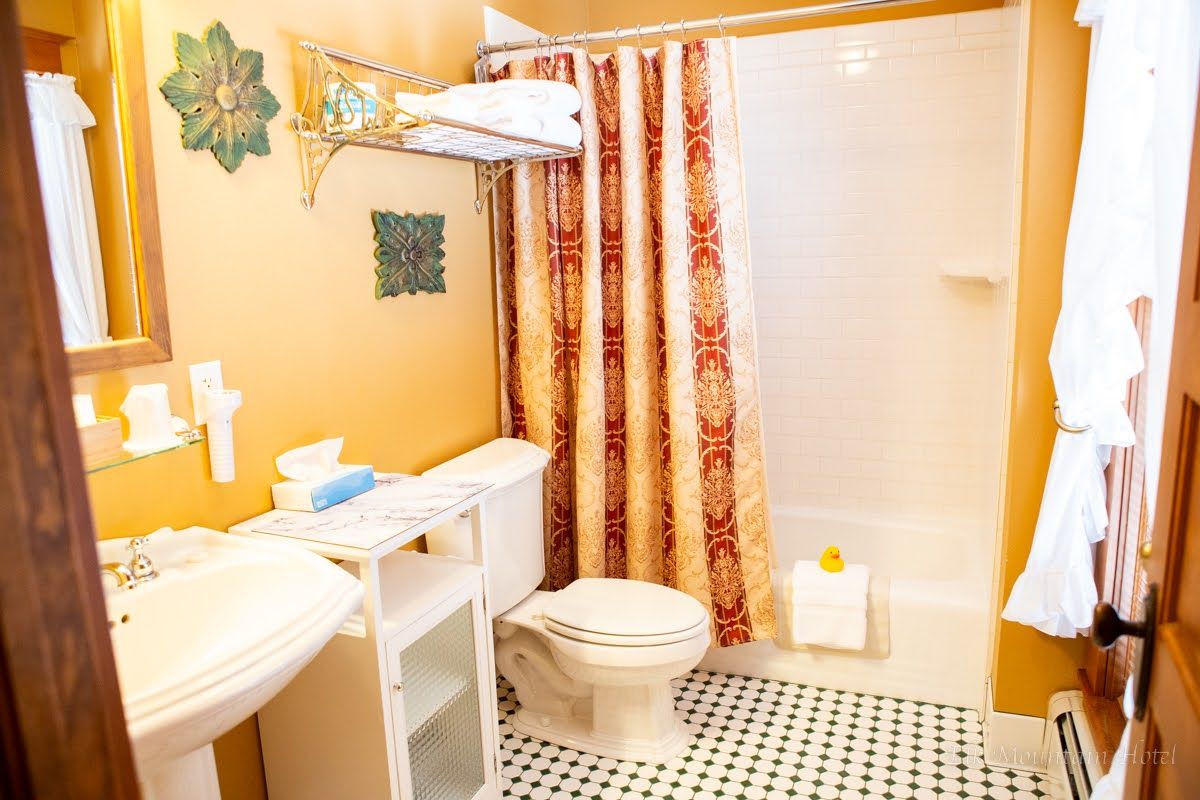 A bathroom with a toilet , sink , and shower.