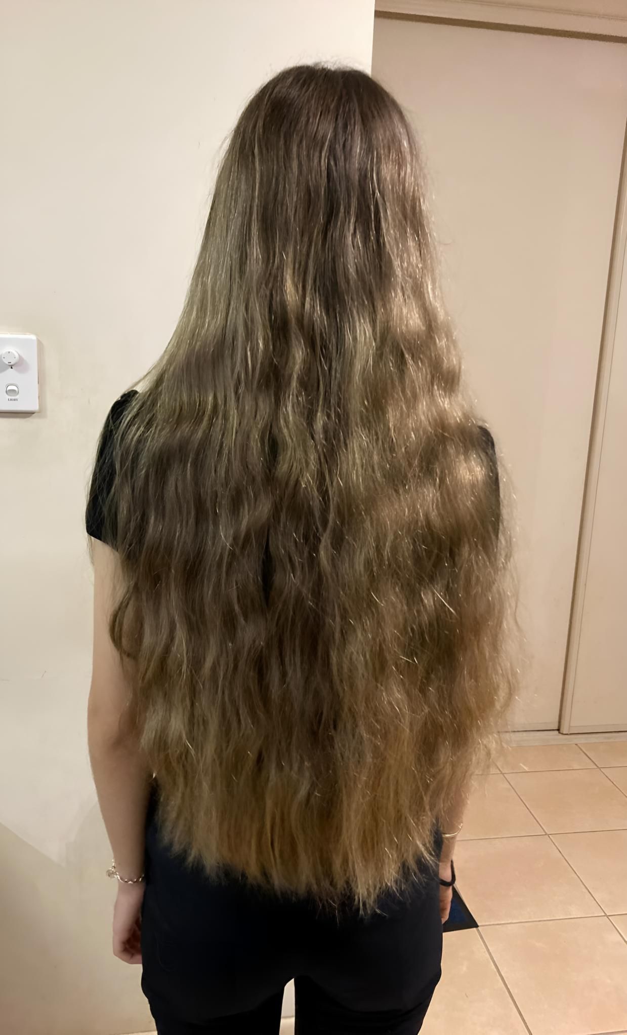 A Woman With Very Long Hair Is Standing In A Room — Klic's Hair Design In Earlville, QLD
