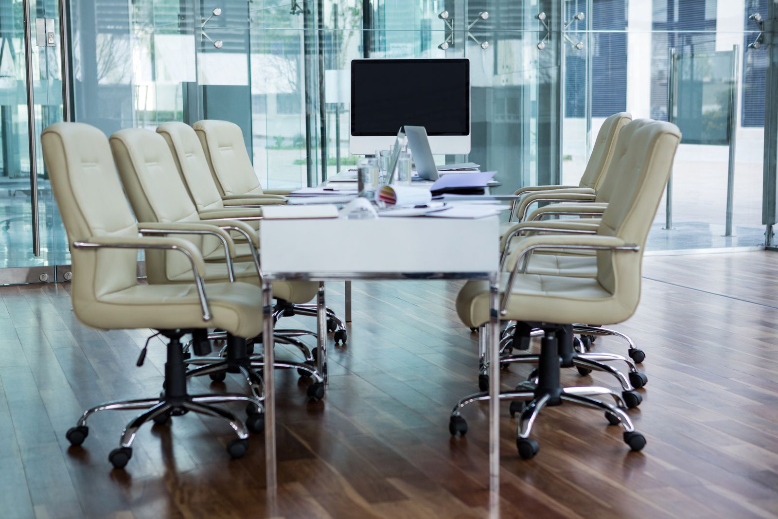 A conference room with chairs and a desk with a computer on it