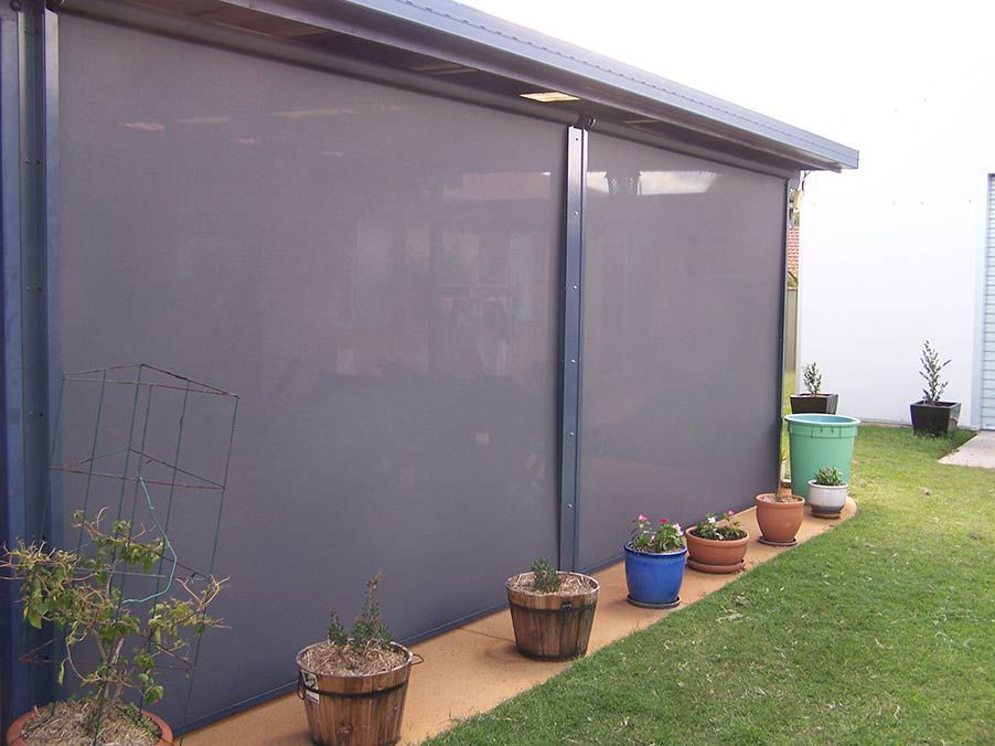 Gray Outdoor Roller Shades on a Patio, With Potted Plants — Toowoomba Shade & Canvas in Harristown, QLD