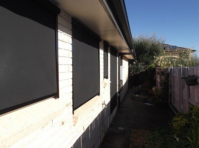 Exterior of a Brick Building With Black Roller Shades Over the Windows — Toowoomba Shade & Canvas in Harristown, QLD
