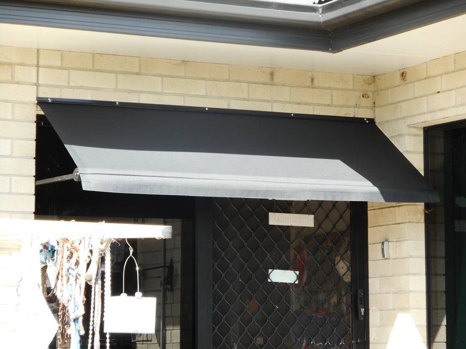 Black Retractable Awning Extended From a Wooden House — Toowoomba Shade & Canvas in Harristown, QLD