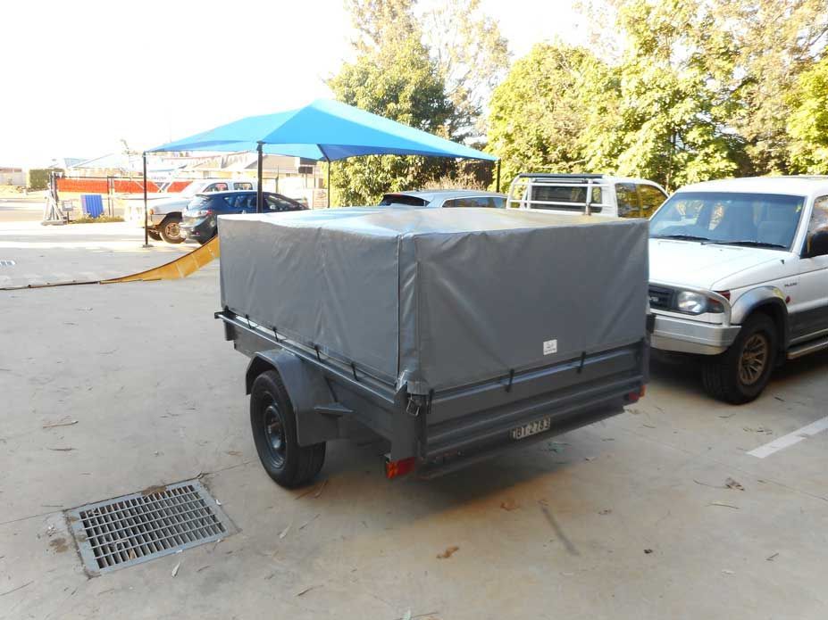Gray Trailer With a Tarp Cover Parked in a Parking Lot — Toowoomba Shade & Canvas in Harristown, QLD