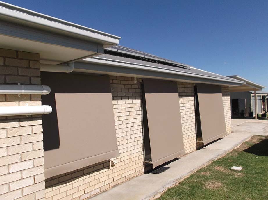 Tan Awnings Covering Windows on a Brick House, Sunny Day — Toowoomba Shade & Canvas in Harristown, QLD