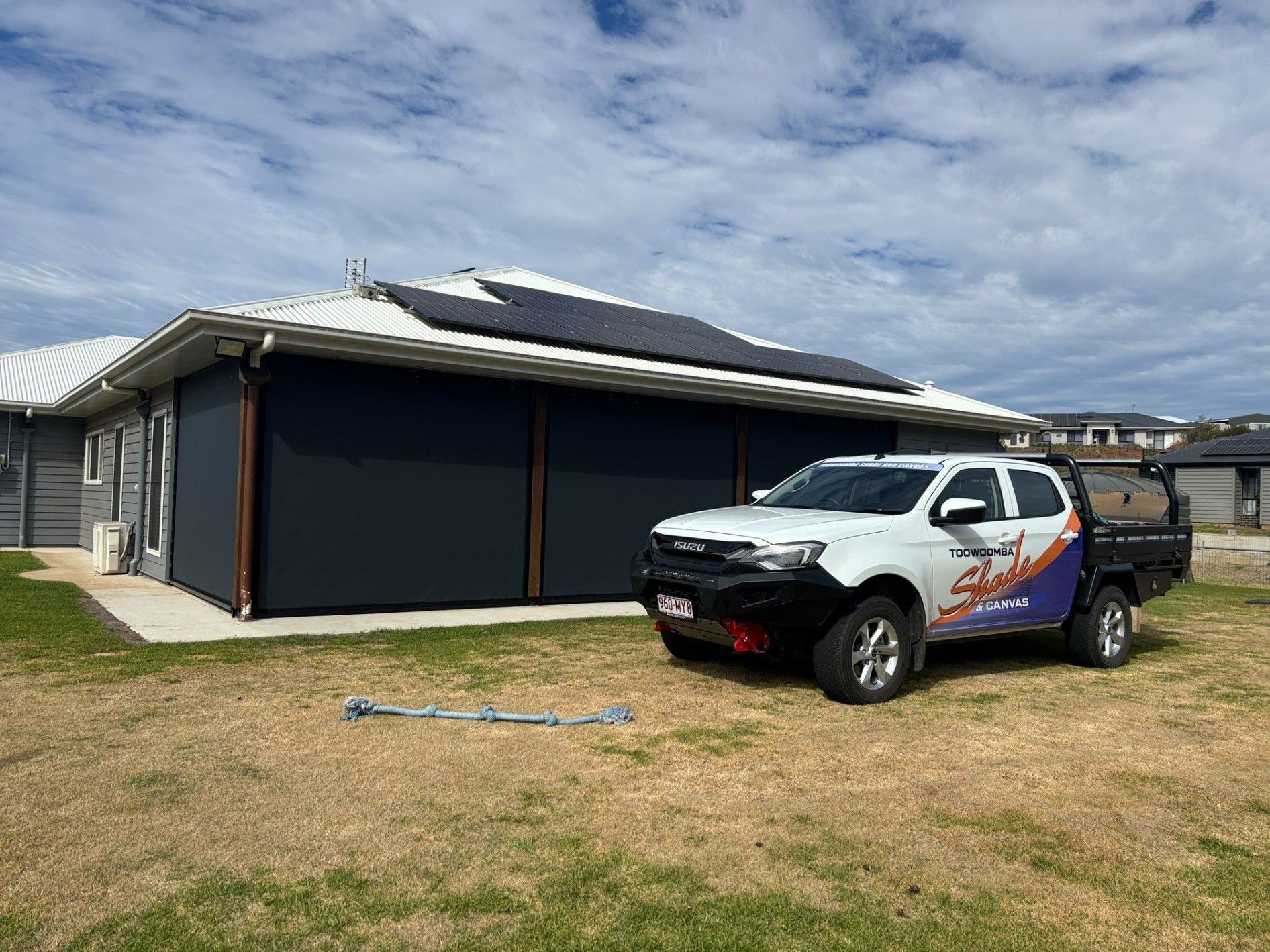 White Truck With Logo Parked Next to House With Dark Blue Shades — Toowoomba Shade & Canvas in Harristown, QLD
