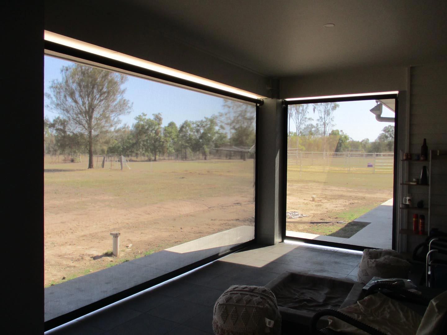 Interior View of a Room With Large Windows Overlooking a Grassy Field