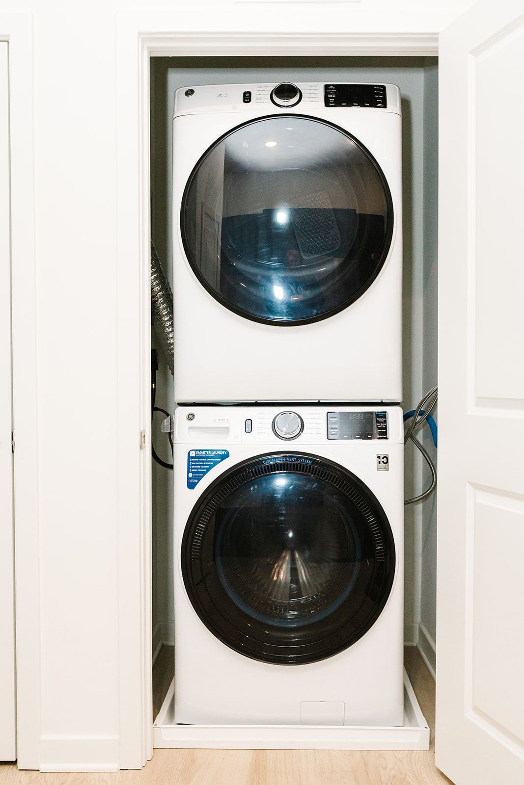 Stacked washer and dryer in a narrow closet, with open doors at Opal Largo Station Apartments in Largo, MD