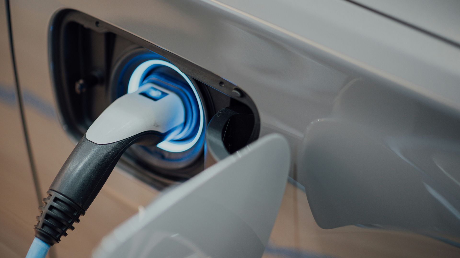 Electric vehicle charging cable plugged into a car’s charging port with a blue illuminated ring at Opal Largo Station Apartments in Largo, MD
