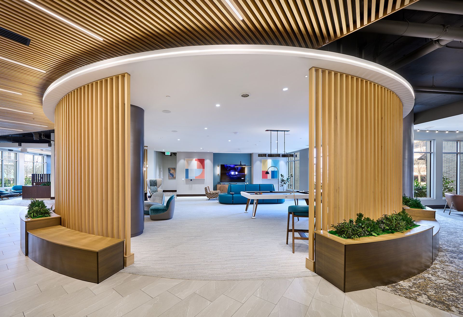 Resident lounge entrance with wood accents and game area at Opal Largo Station Apartments in Largo, MD.