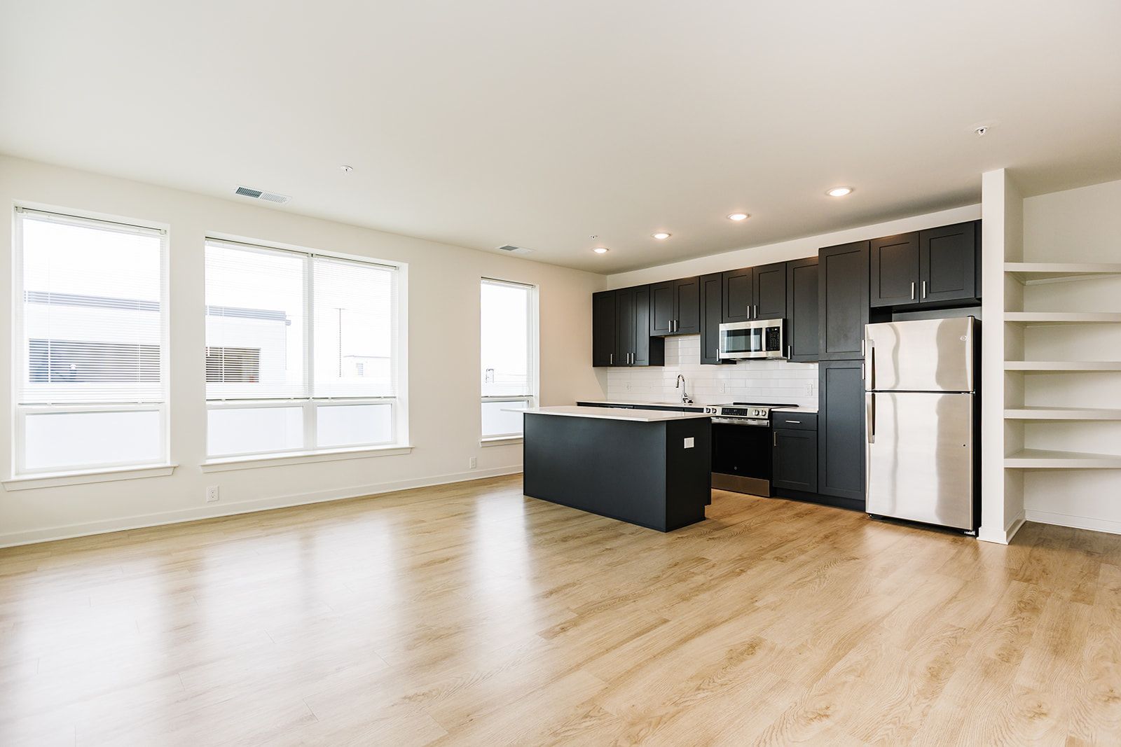 Spacious open-concept apartment with kitchen and large windows at Opal Largo Station Apartments in Largo, MD.