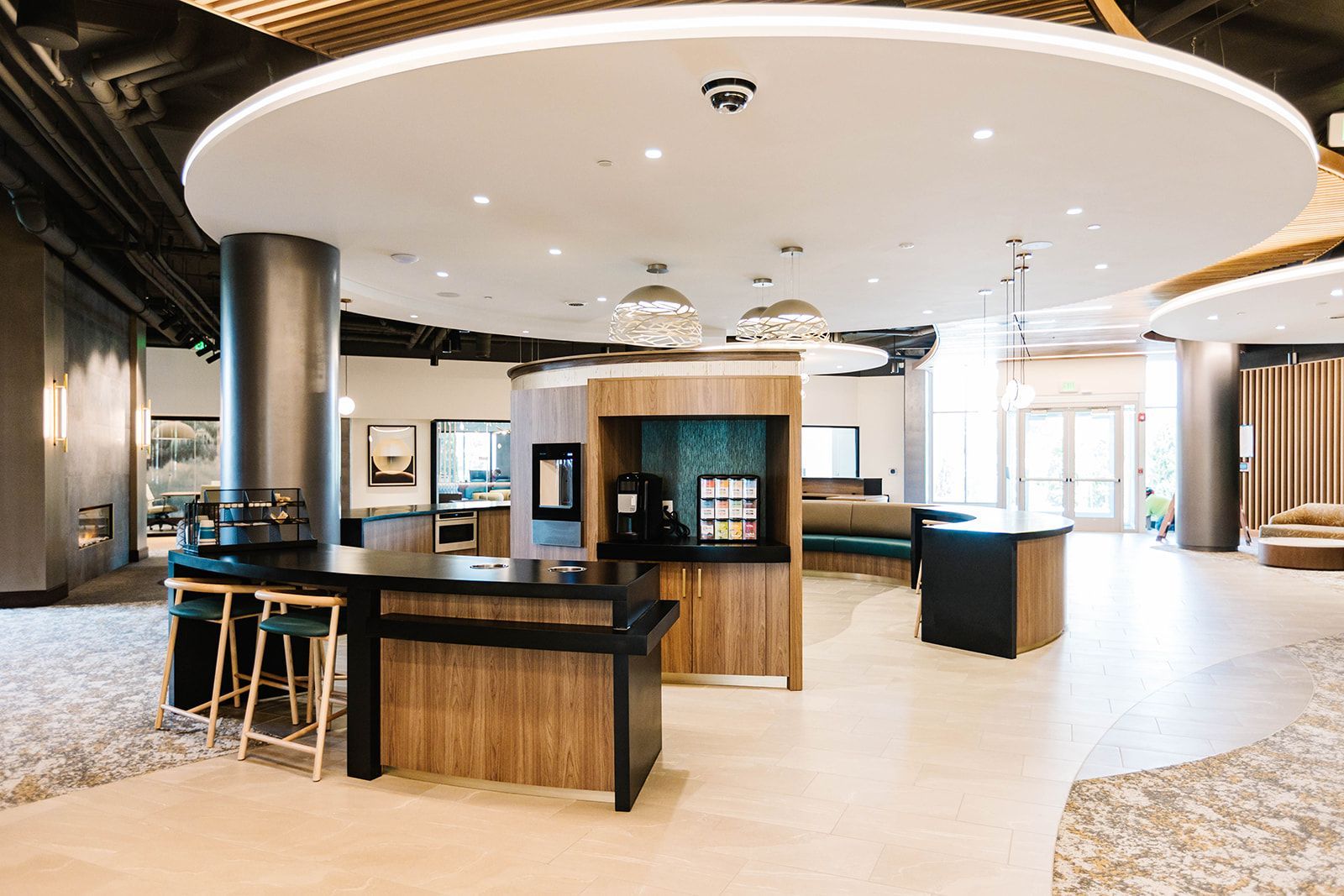 Modern hotel lobby with reception desk, round ceiling lights, and seating area at Opal Largo Station Apartments in Largo, MD