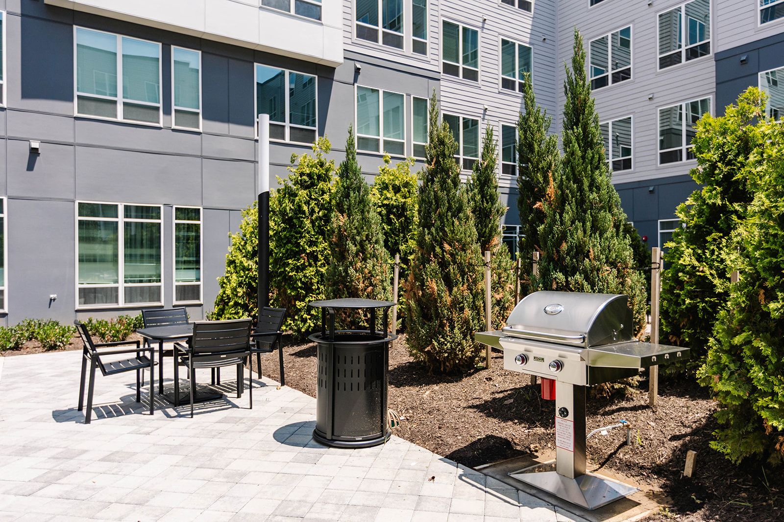 Outdoor grilling area with tables and seating at Opal Largo Station Apartments in Largo, MD.