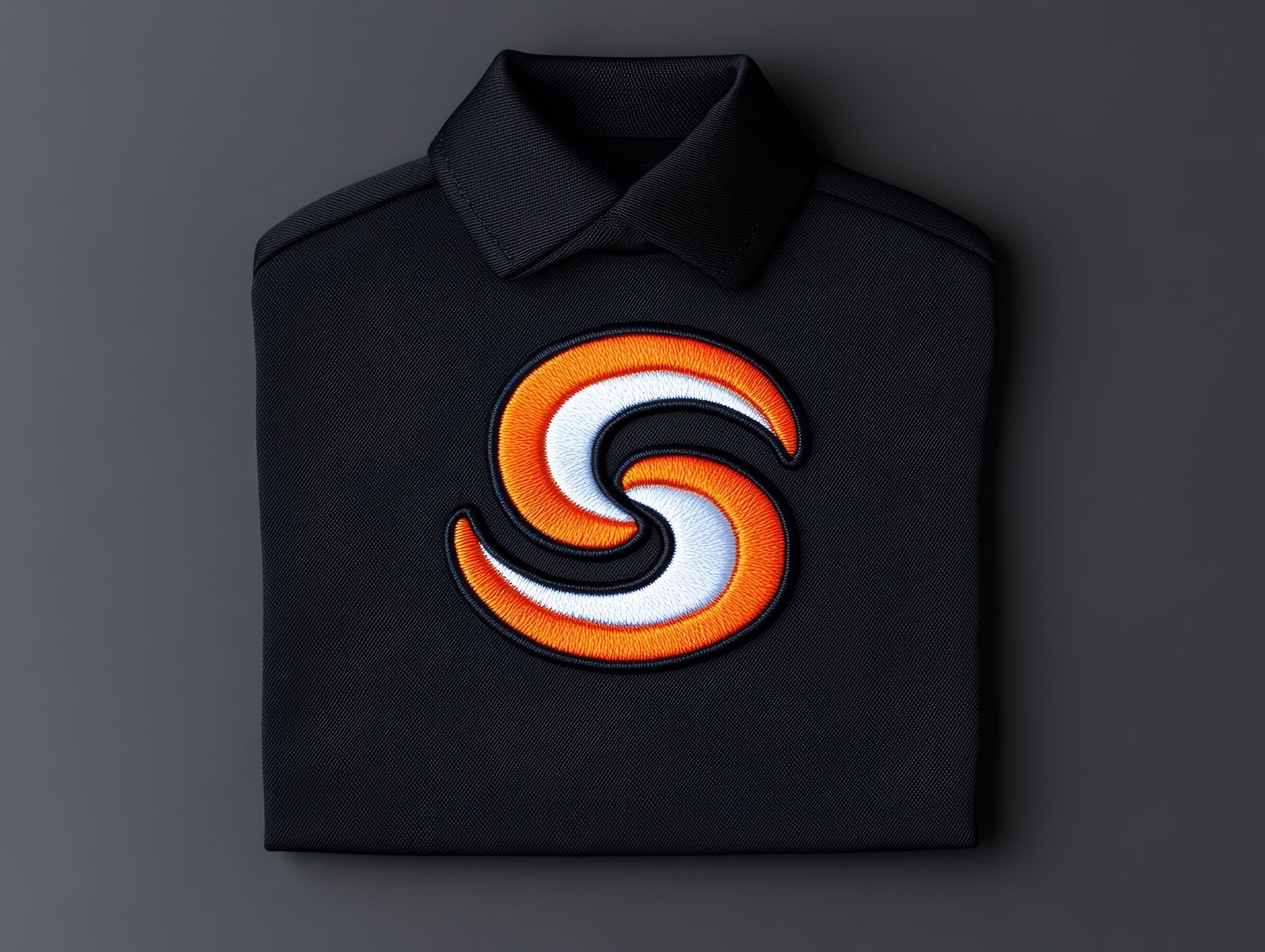 Black polo shirt with a circular orange and white logo on the chest.