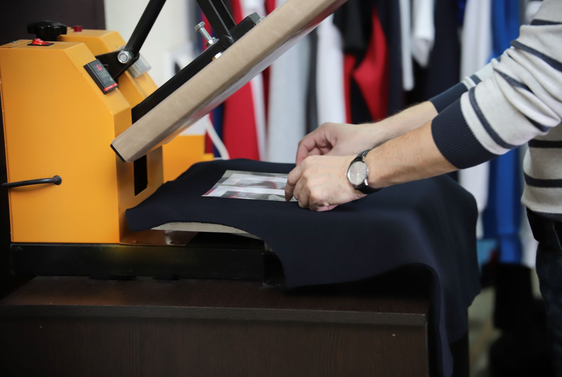 Navy blue suit jacket on a mannequin with a yellow measuring tape draped over it; gray background.