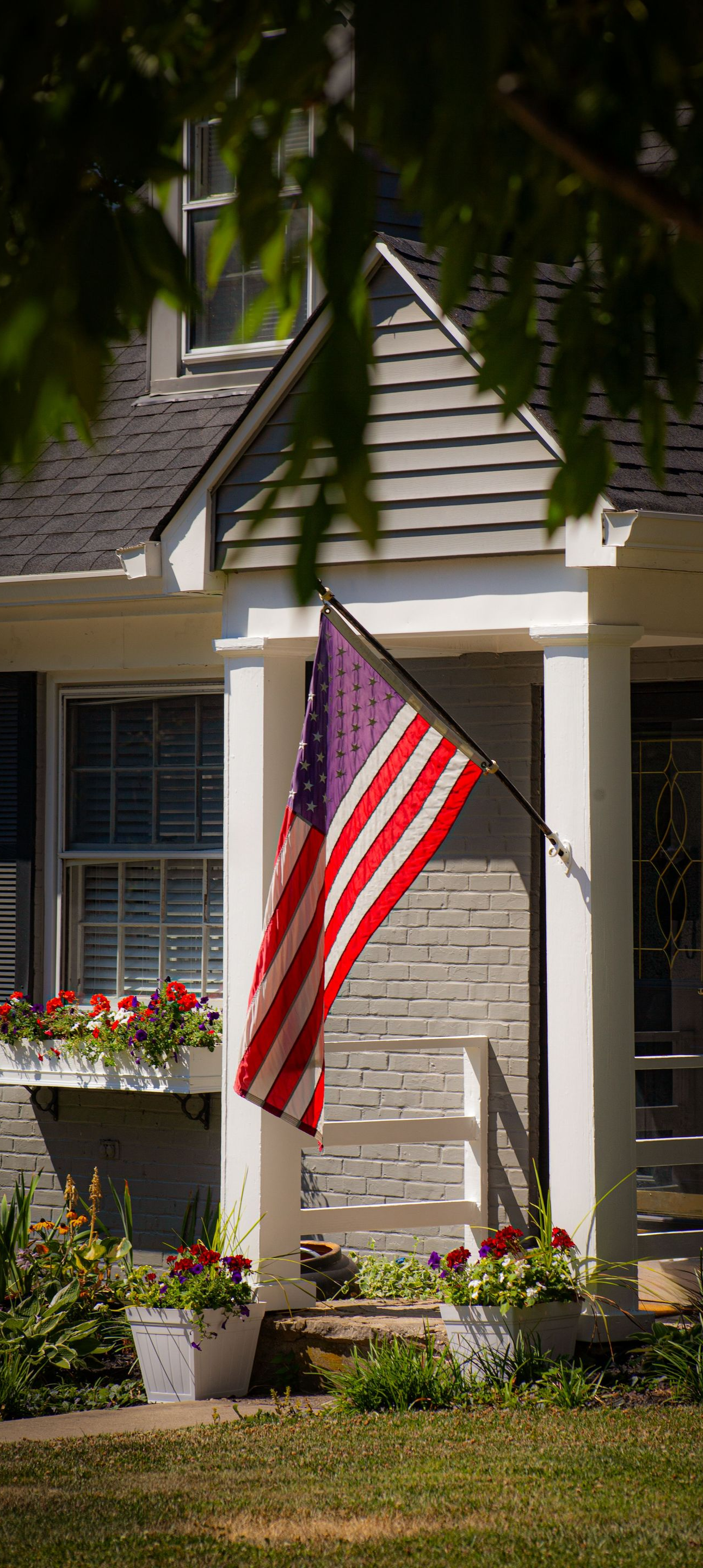 House with a hanging American flag by the front porch
