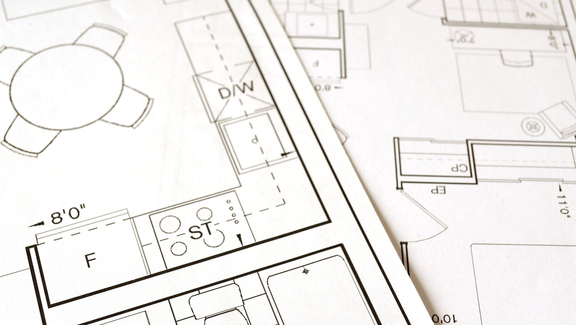 Architectural floor plan drawing with rooms, furniture symbols, and measurements on white paper