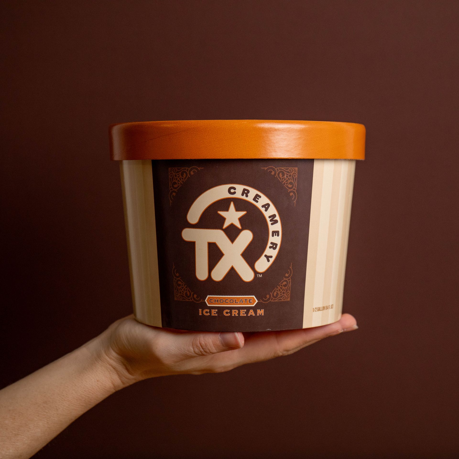 TX Creamery half gallon resting on a woman's hand