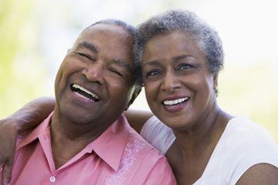 A man and a woman are laughing together and hugging each other.