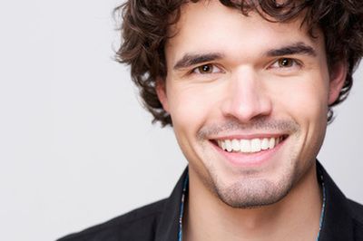 A man with curly hair and a beard is smiling for the camera.