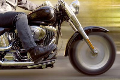A man is riding a motorcycle down a road.