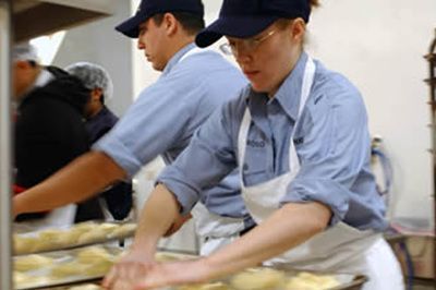 A man and a woman are preparing food in a kitchen.