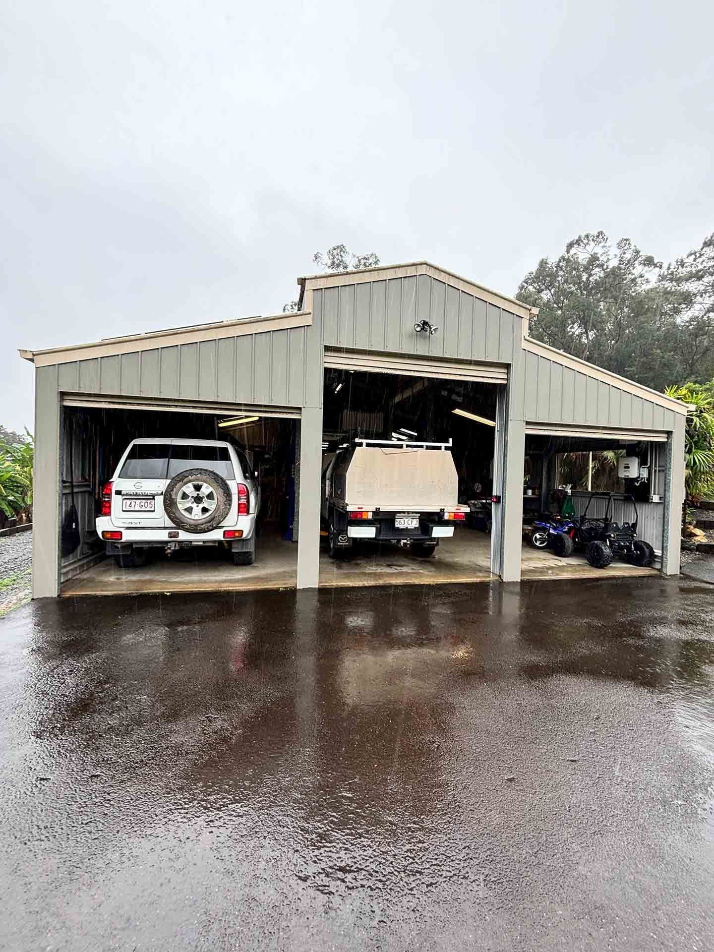 Two Cars Are Parked In A Garage On A Rainy Day — Master Mechanix In Yandina Creek, QLD