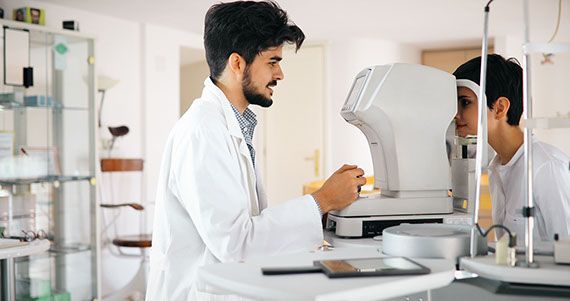 a doctor is examining a patient 's eye with a machine .